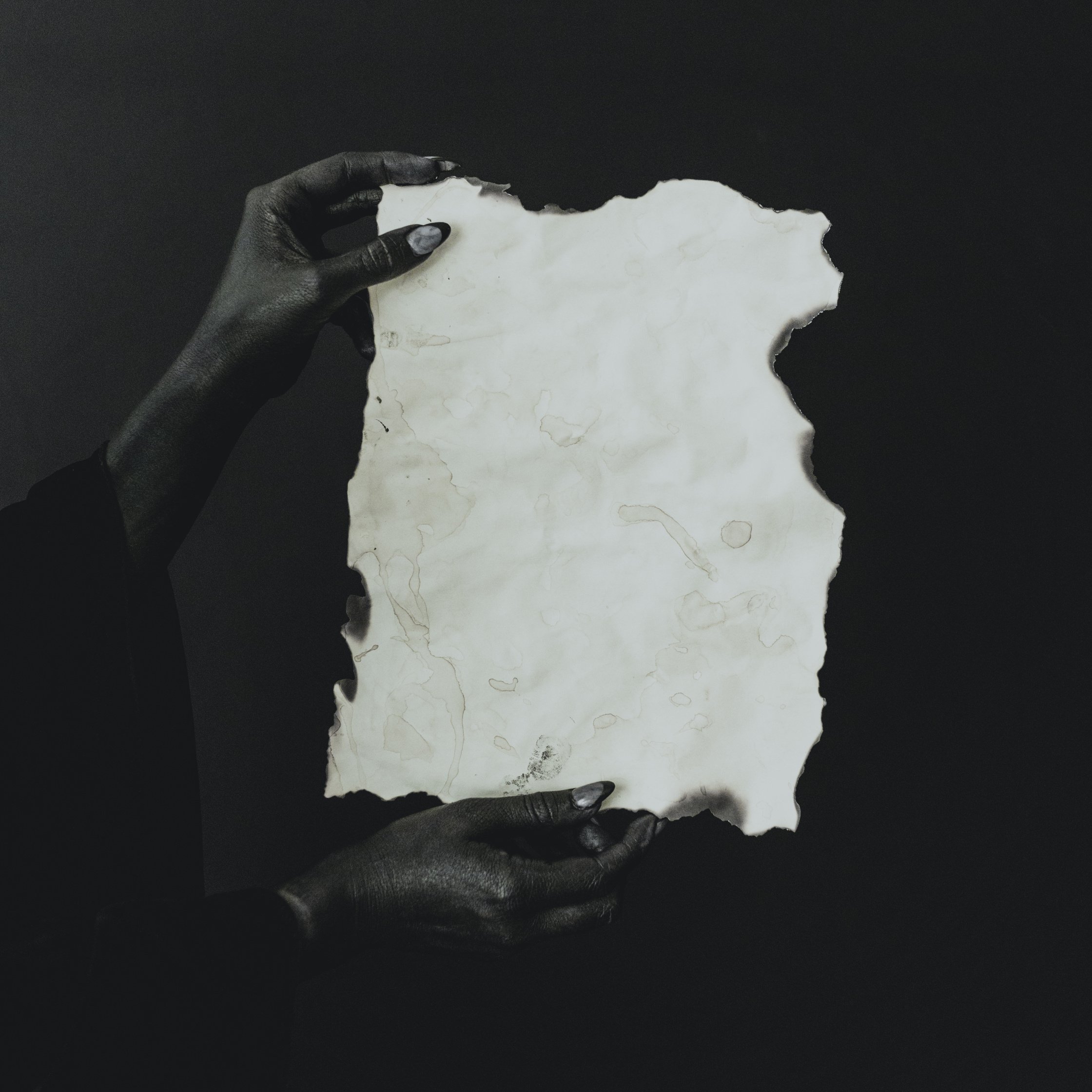 Black Hands Holding Blank Sheet of Paper